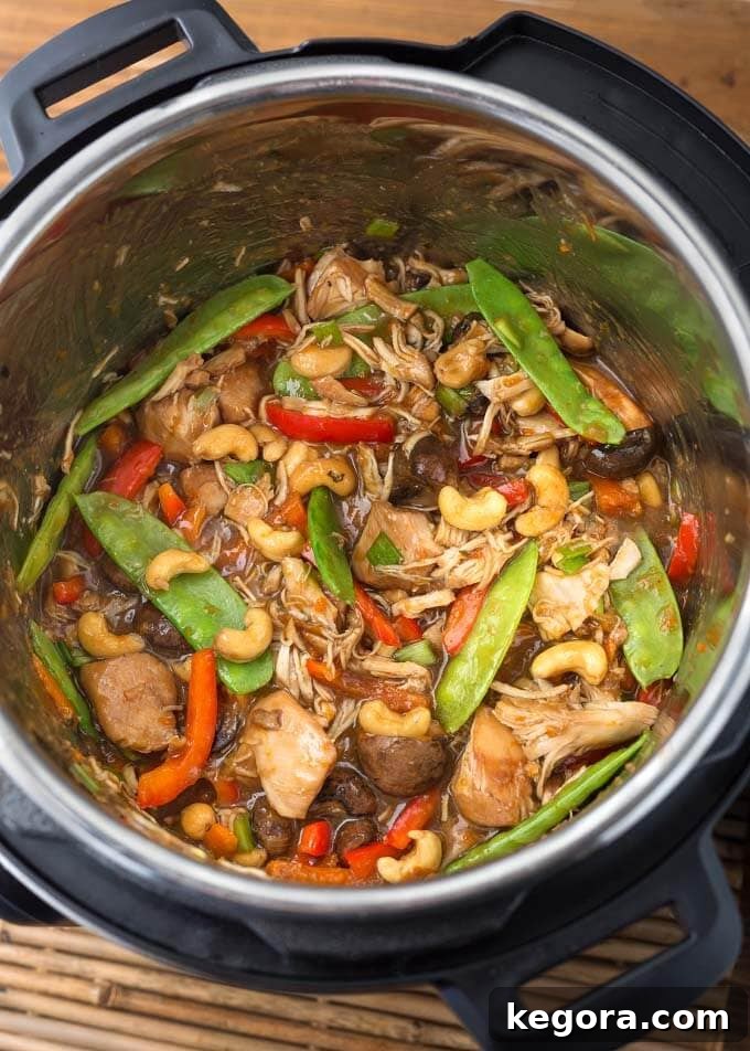 Quick and Delicious Instant Pot Cashew Chicken 3 Cashew Chicken cooking in a pressure cooker pot, showing chicken pieces and sauce
