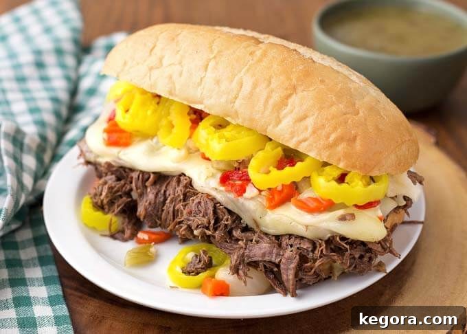 Ultimate Instant Pot Italian Beef 4 Italian Beef hoagie on white plate on wooden board