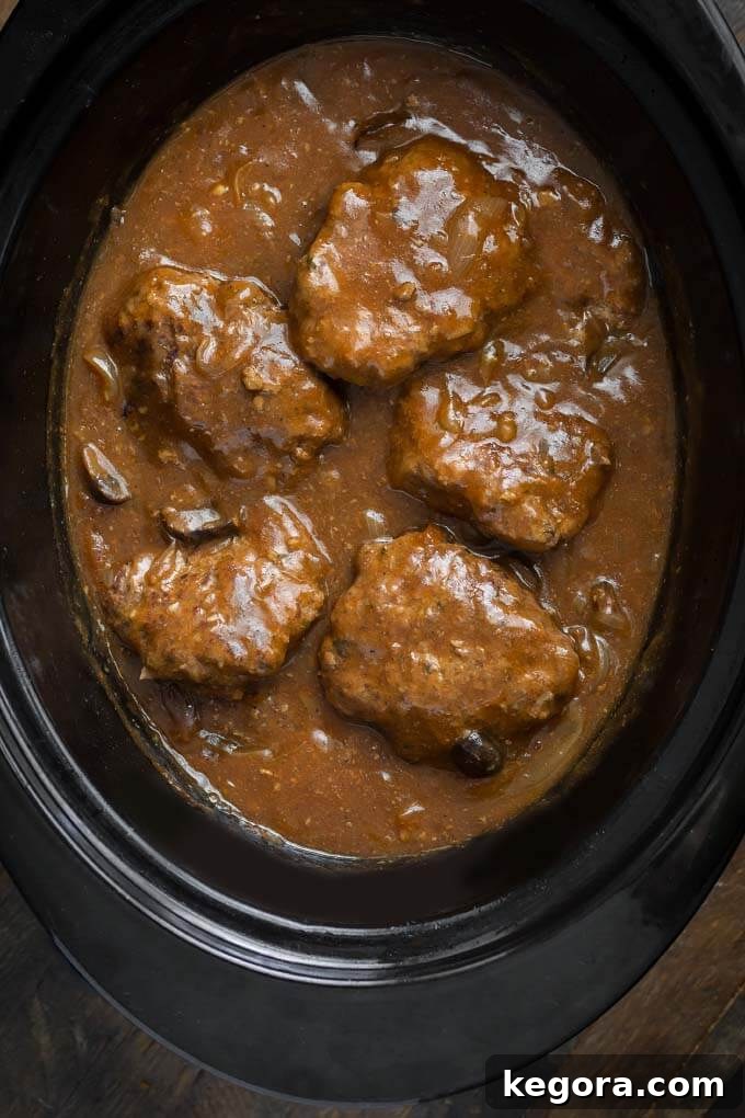 Salisbury Steak in slow cooker, simmering in rich gravy