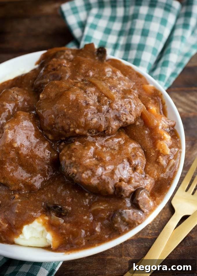 Salisbury Steak served on a white plate with mashed potatoes