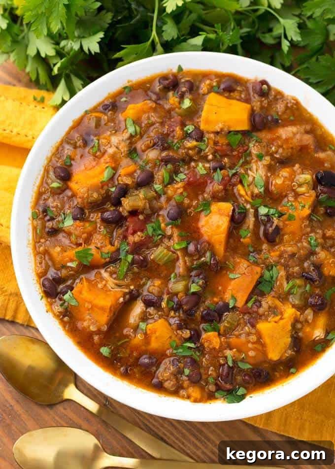 Pressure cooker Instant Pot Sweet Potato Quinoa Chicken Chili in a white bowl on a yellow napkin, ready to be served.