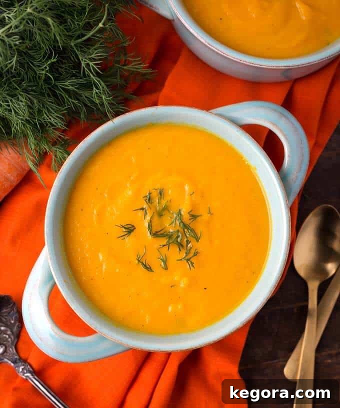 Velvety Instant Pot Carrot Puree 2 Pressure Cooker Carrot Soup in a light blue bowl on orange background
