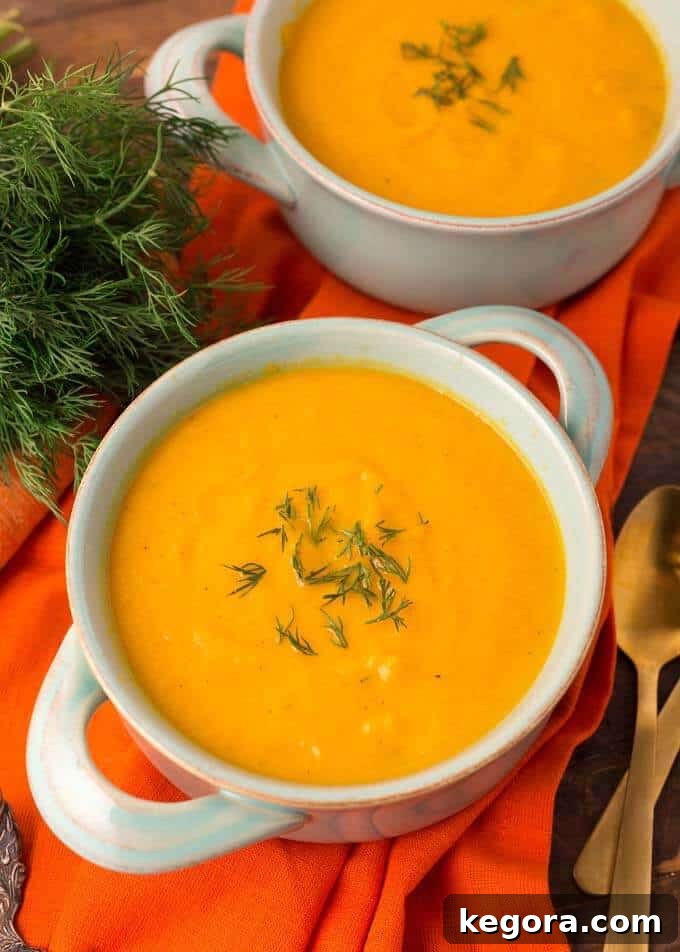 Velvety Instant Pot Carrot Puree 4 Pressure Cooker Carrot Soup in a light blue bowl on orange background