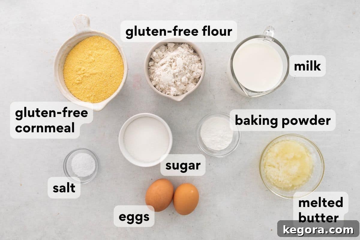 Various pre-measured ingredients laid out neatly for gluten-free corn muffins, including flour, cornmeal, sugar, eggs, milk, and melted butter.