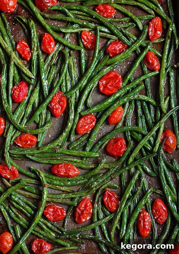 Spicy Roasted Green Beans and Burst Tomatoes 2 Oven-roasted spicy green beans and cherry tomatoes on a baking sheet, ready to serve.