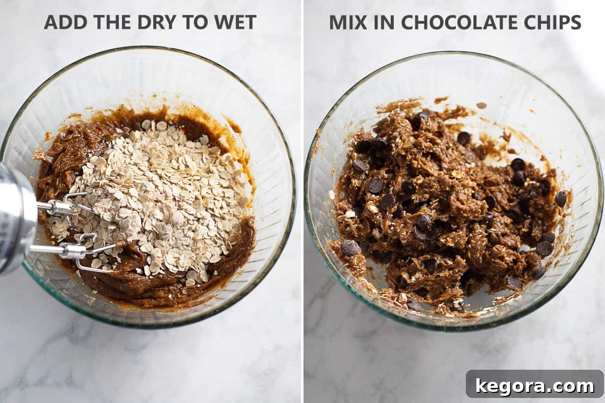 Wholesome Flourless Oatmeal Almond Butter Cookies 6 Adding the oat mixture and chocolate chips into the creamy almond butter dough in a large mixing bowl, illustrating the combining of wet and dry ingredients.