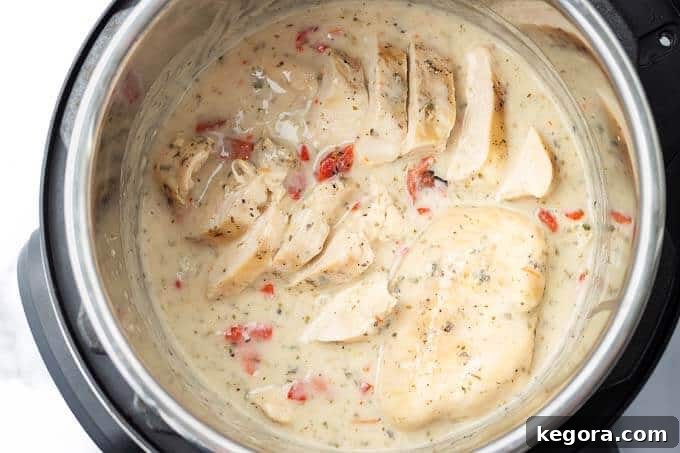 Cooked chicken breasts in a pressure cooker pot with creamy Italian sauce