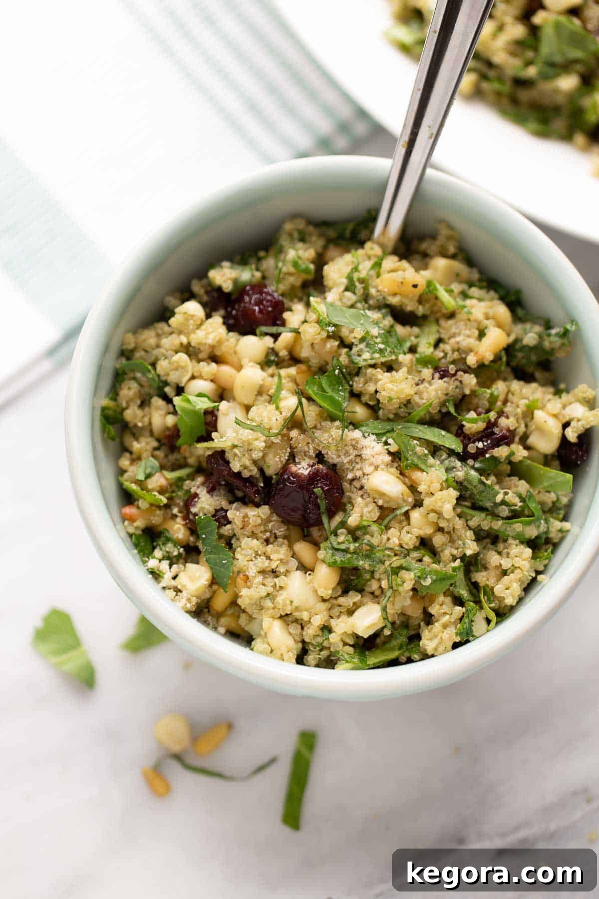 The Ultimate Quinoa Salad Recipe with Buttermilk Basil Dressing A large bowl of the best quinoa salad with pine nuts, corn, cranberries, greens, and parmesan, tossed in creamy buttermilk basil dressing.