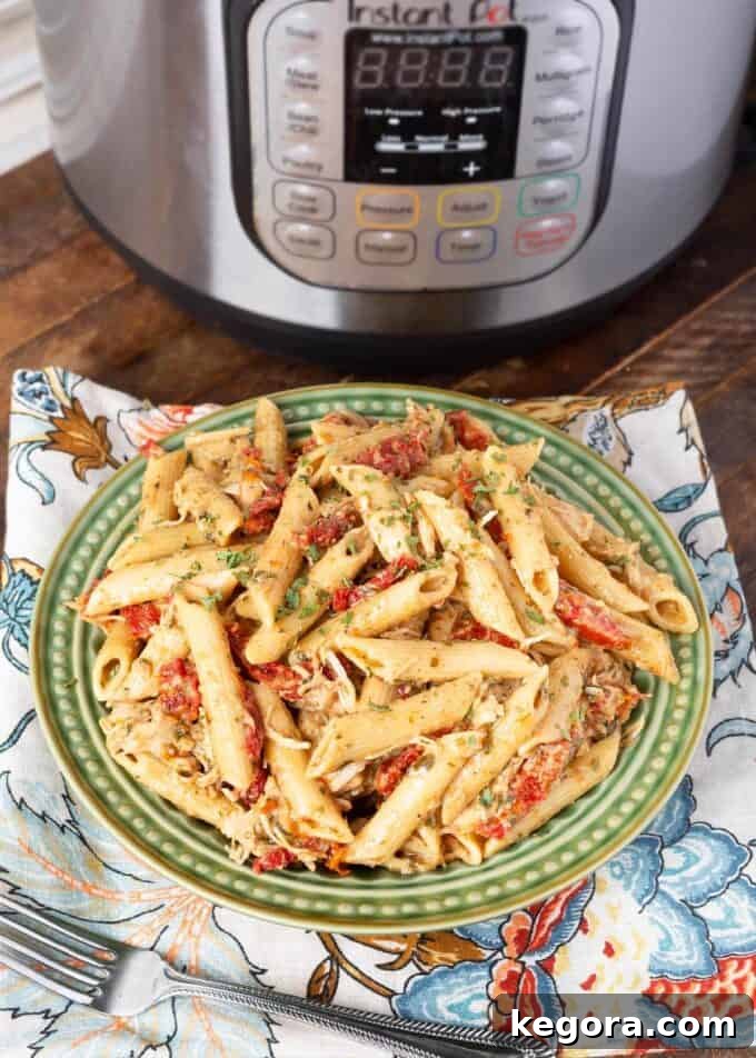 Pressure cooker Pesto Pasta on green plate in front of pressure cooker