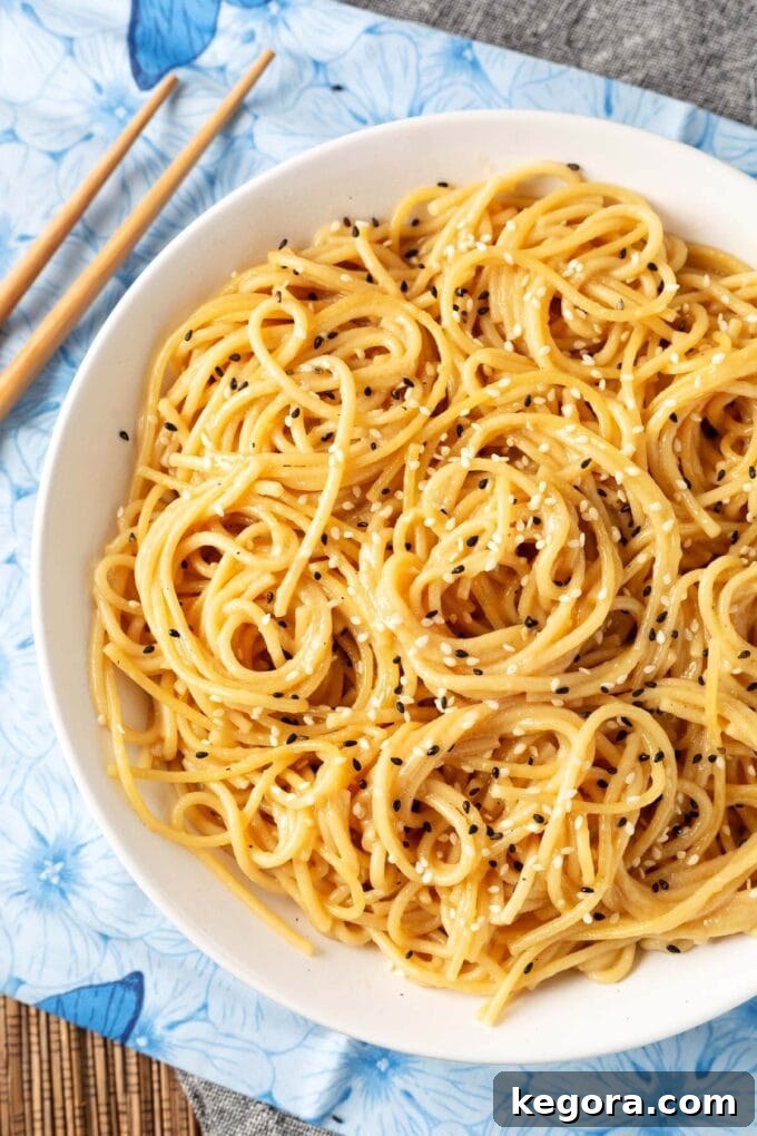 Garlic Noodle Express 2 A perfectly portioned bowl of Instant Pot Garlic Noodles, ready to be enjoyed, with wooden chopsticks resting on the side.