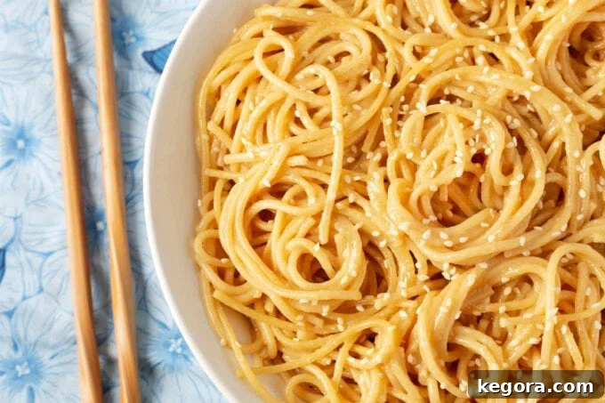 Garlic Noodle Express 3 Close-up shot of the savory Instant Pot Garlic Noodles in a white bowl, garnished and ready to serve with chopsticks.