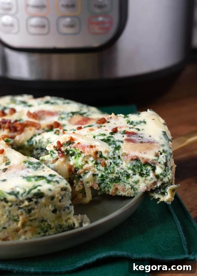 Delicious slice of Instant Pot Spinach Bacon Crustless Quiche on a grey plate with a fork