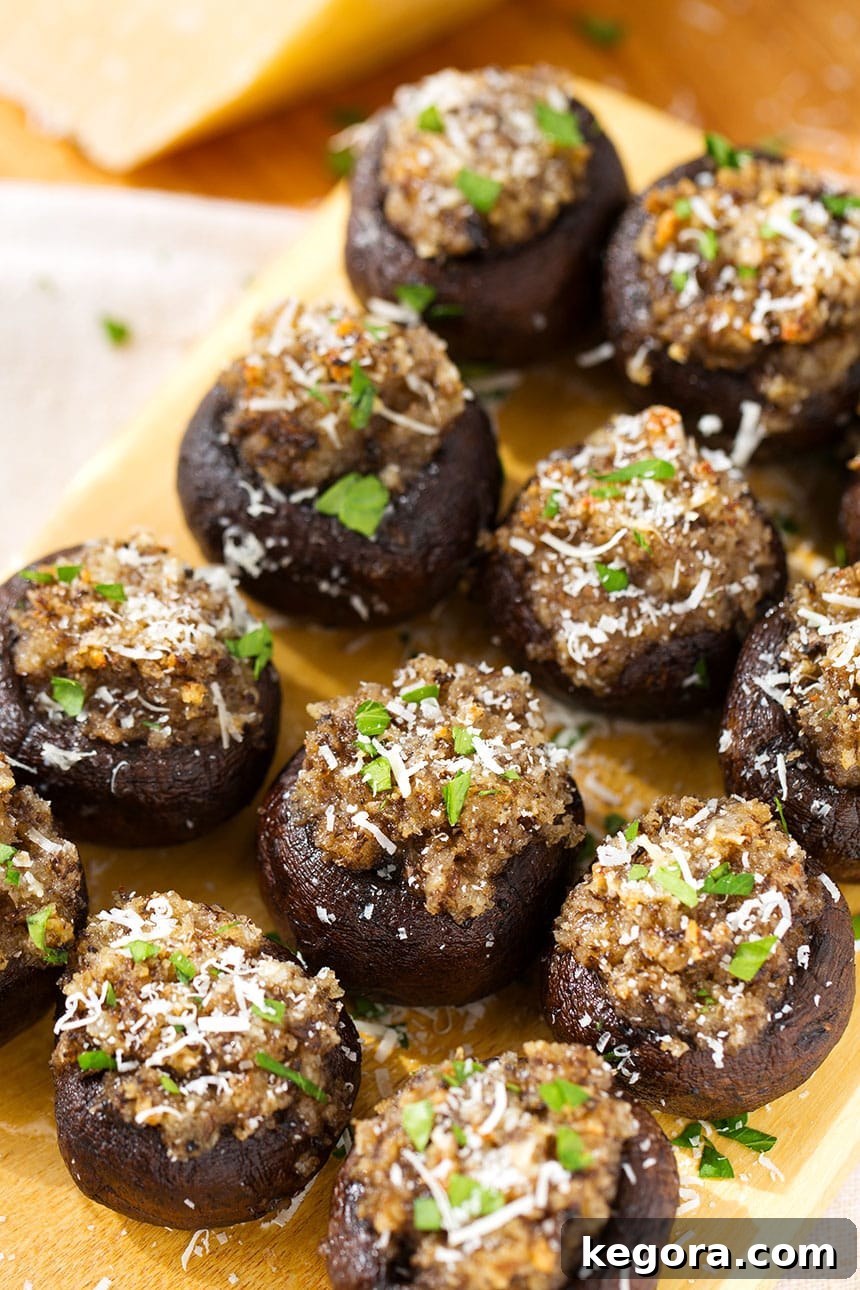 Irresistible Garlic Stuffed Mushrooms 2 A close-up shot of several Easy Garlic Stuffed Mushrooms arranged beautifully on a rustic wooden board, ready to be served as an appetizer.
