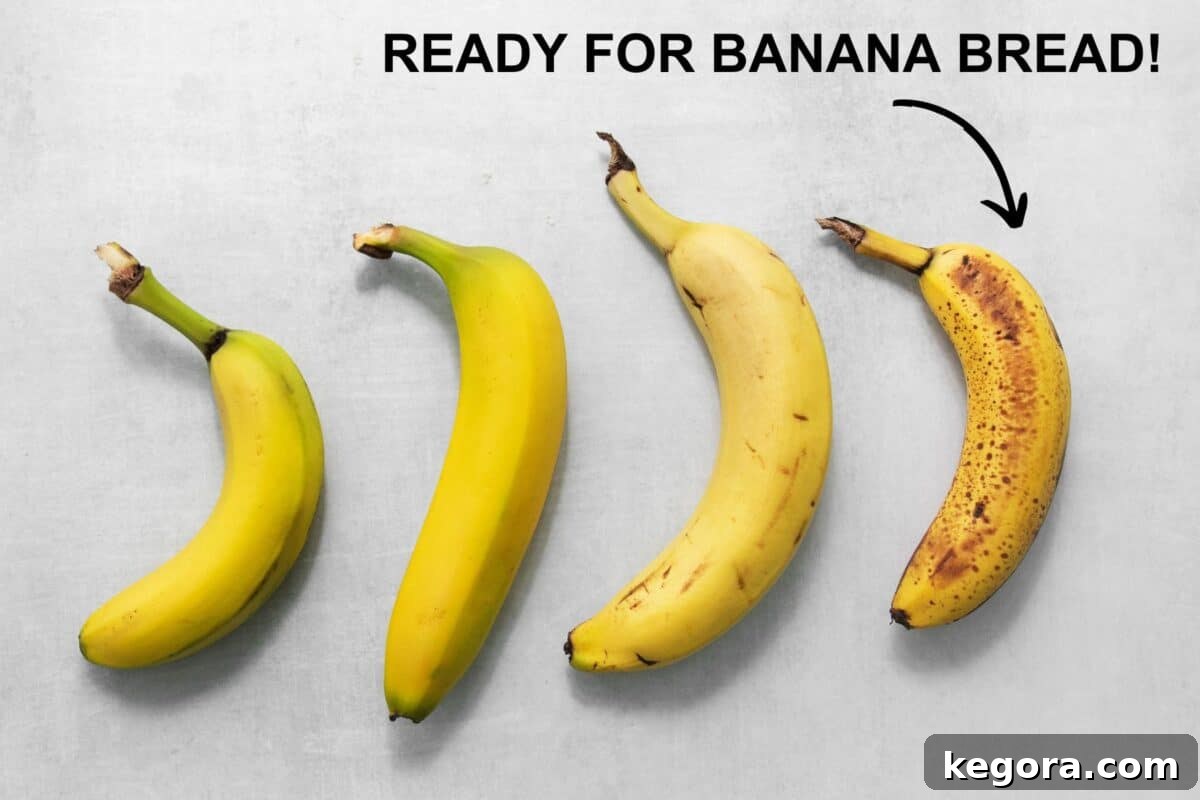 Overhead shot of bananas at different stages of ripeness, highlighting very ripe ones for banana bread