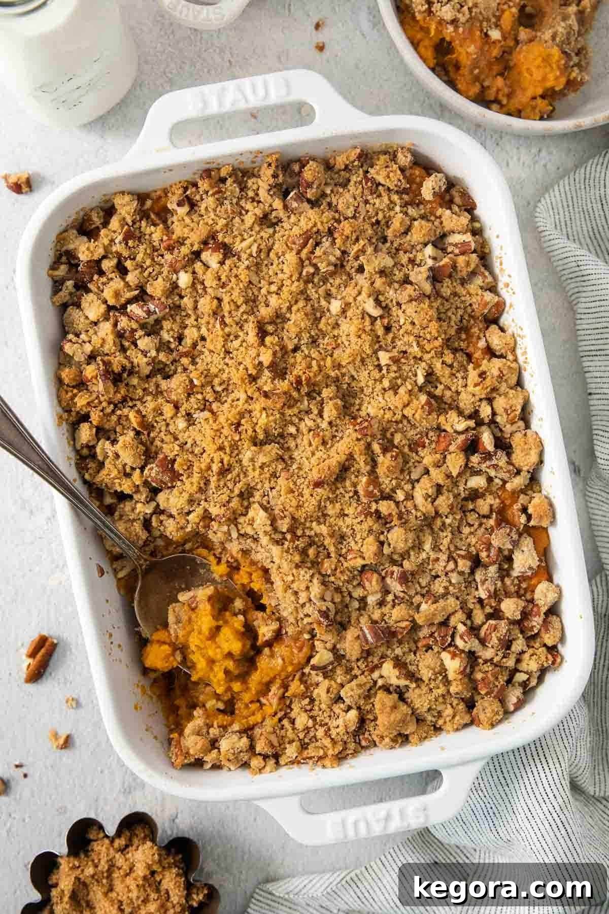 The Ultimate Gluten-Free Sweet Potato Casserole with Praline Pecan Crunch 2 Creamy gluten-free sweet potato casserole in a white baking dish, topped with a golden-brown pecan praline crust.