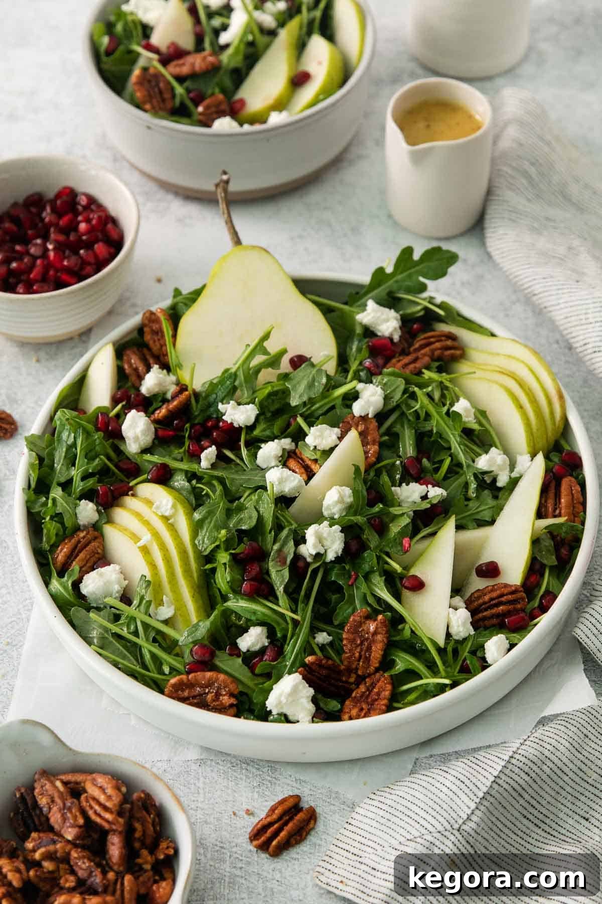 Fresh arugula pear salad in a rustic wooden bowl, showcasing vibrant greens, sliced pears, and goat cheese