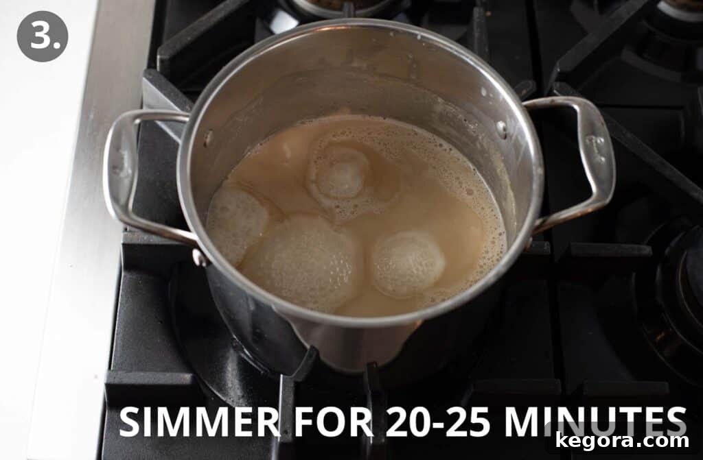 Simple Vegan Fudge 6 Reduced coconut milk and honey mixture in a metal pot, showcasing its thickened, condensed consistency after simmering.
