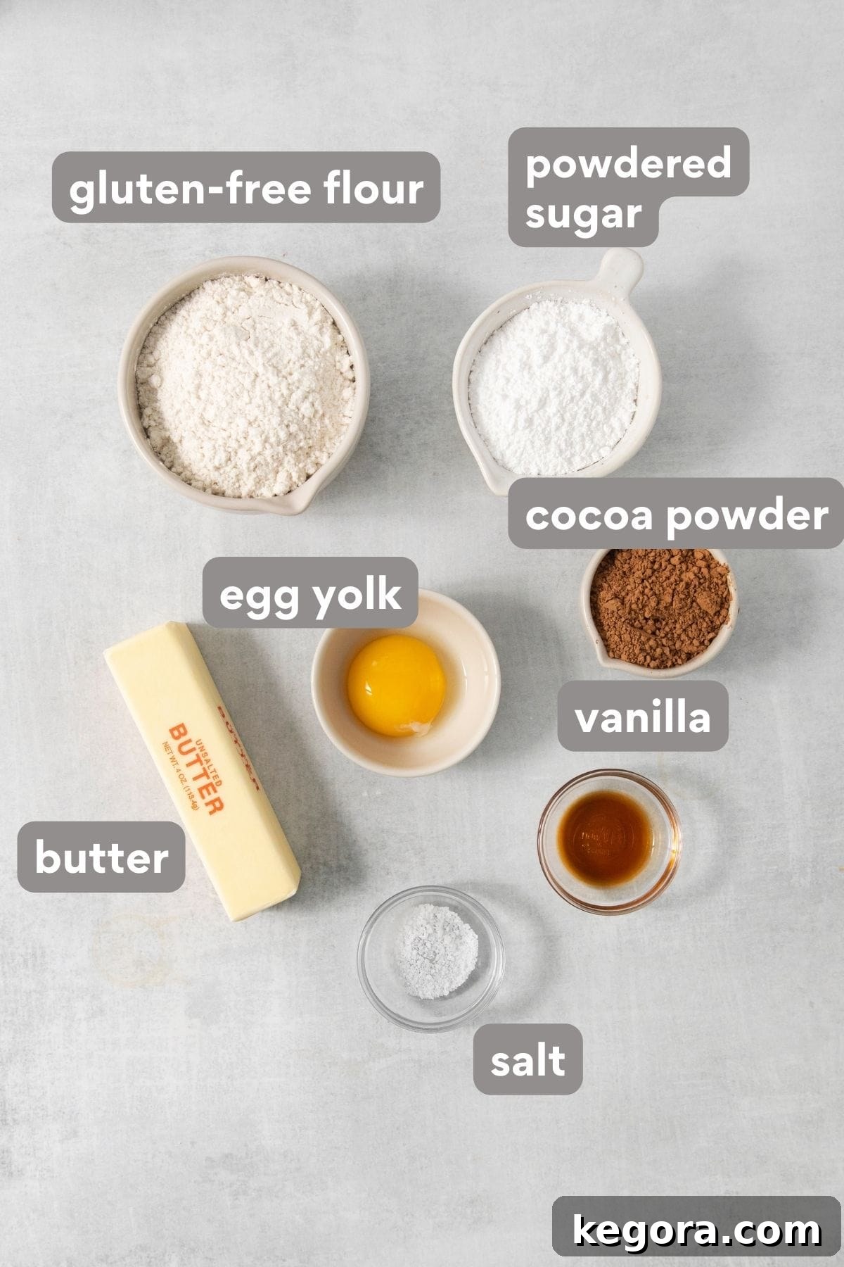 Array of ingredients for gluten-free chocolate caramel tart including flour, cocoa powder, butter, and sugar