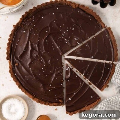 Gluten-free chocolate caramel tart sliced on a countertop