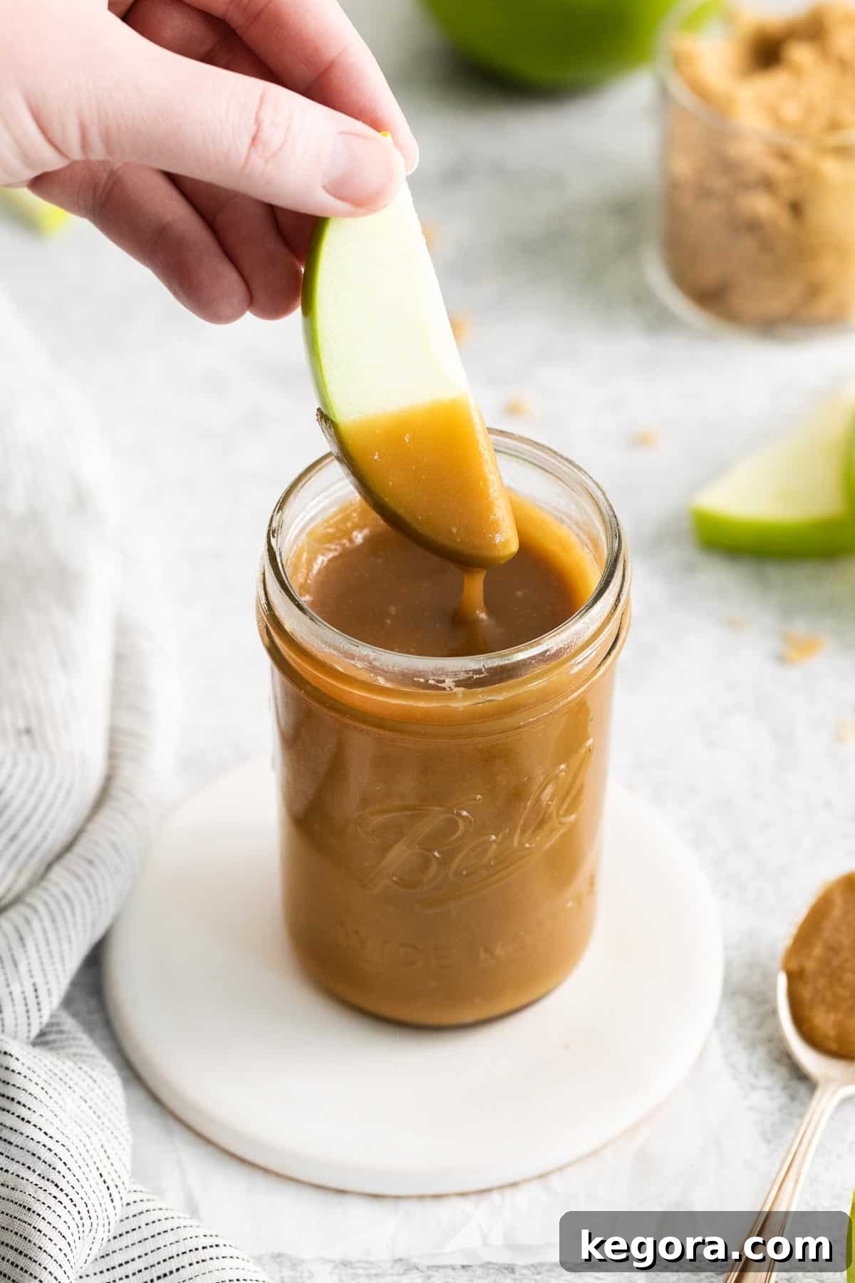 Dairy-free caramel in a jar with a spoon in it