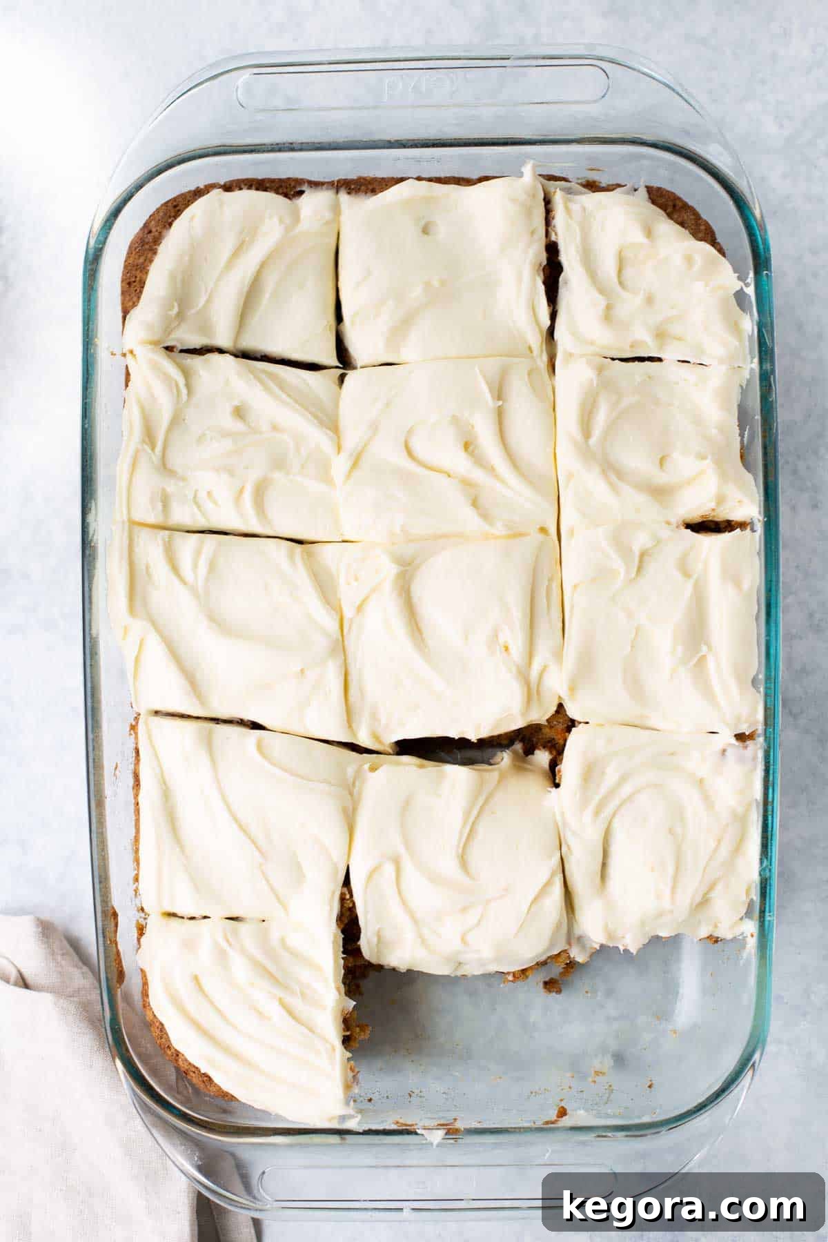 A 9x13 pan filled with perfectly cut squares of moist gluten-free carrot cake, ready to be served.