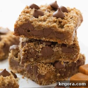 Stack of gluten free oatmeal cookie bars with chocolate and caramel on white marble background