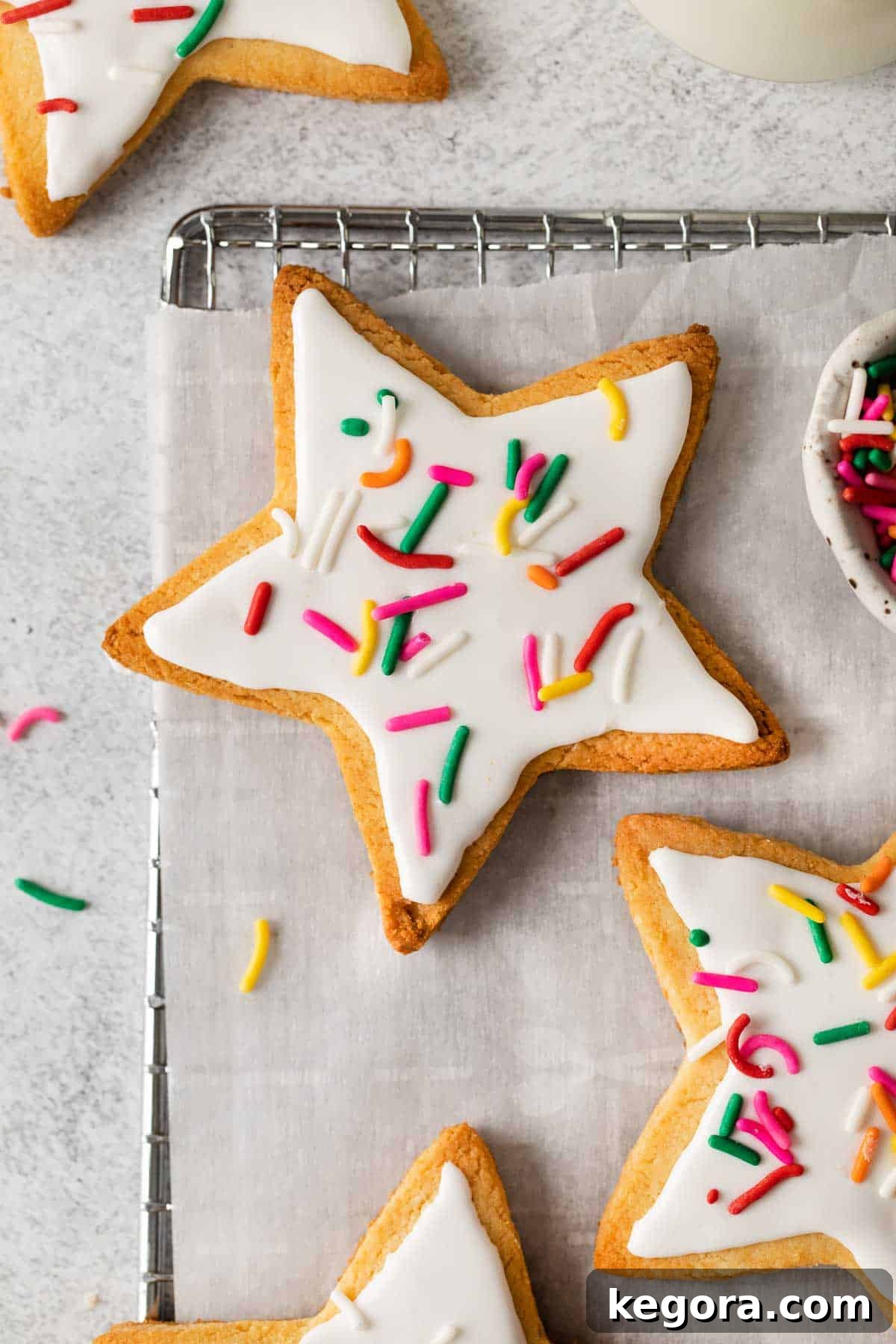 Ultimate Almond Flour Sugar Cookies 11 close up of almond flour sugar cookies topped with white frosting and sprinkles