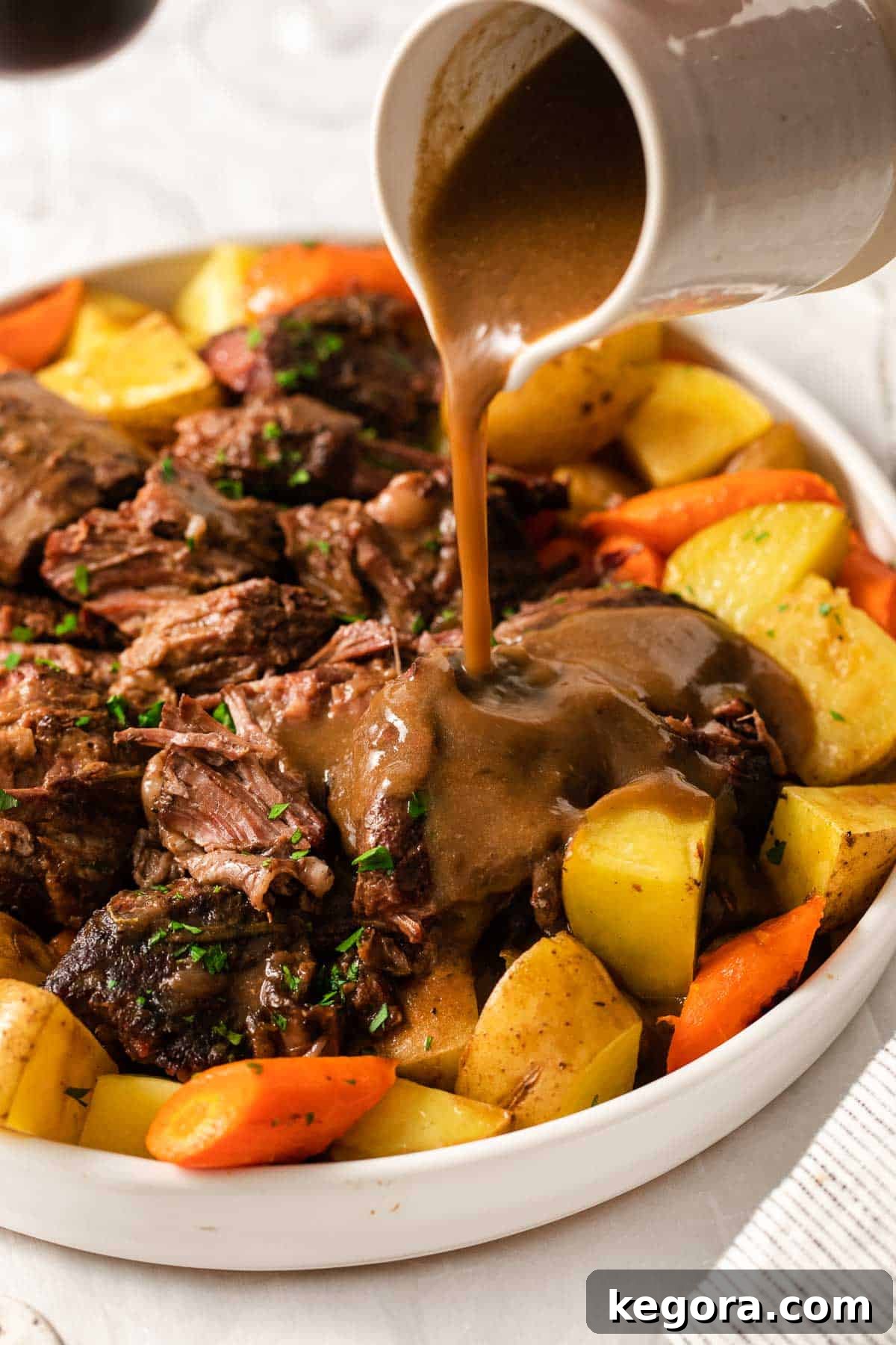 The Perfect Gluten-Free Family Pot Roast 2 Tender gluten-free pot roast with rich porcini mushroom gravy being poured over it, ready to be served