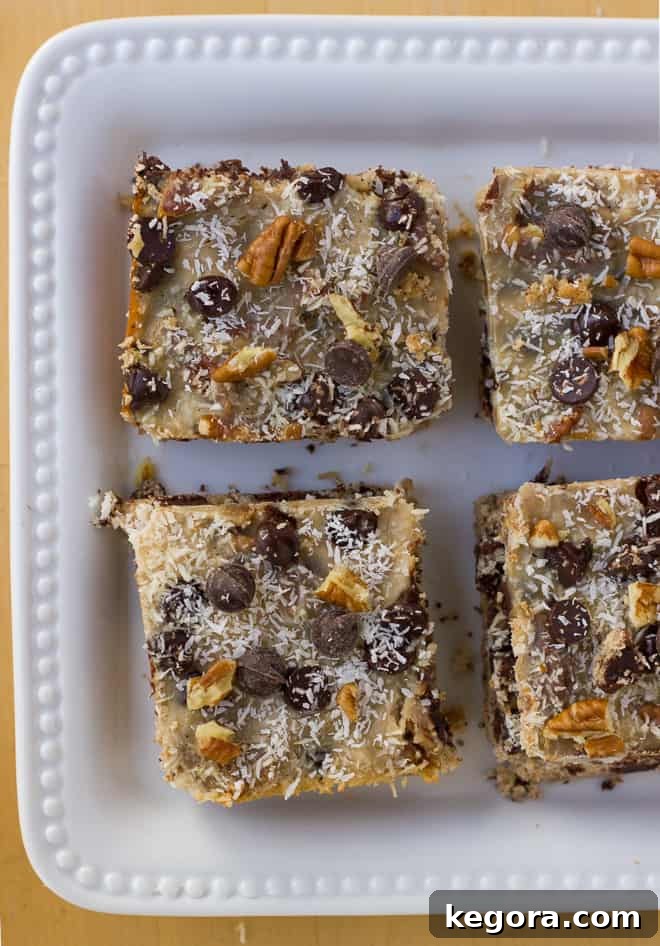 Aerial view of a batch of Grain-Free Magic Cookie Bars on a white baking sheet