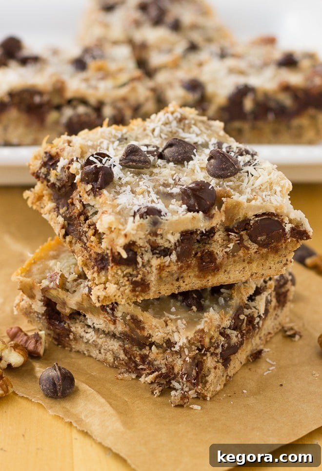 Stack of two Grain-Free Magic Cookie Bars, showing off their distinct layers