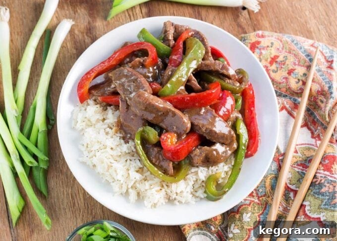 Instant Pot Pepper Steak served on a white plate with a rustic wood background