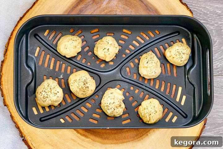Air Fryer Mozzarella Balls arranged in a single layer in the air fryer basket before cooking