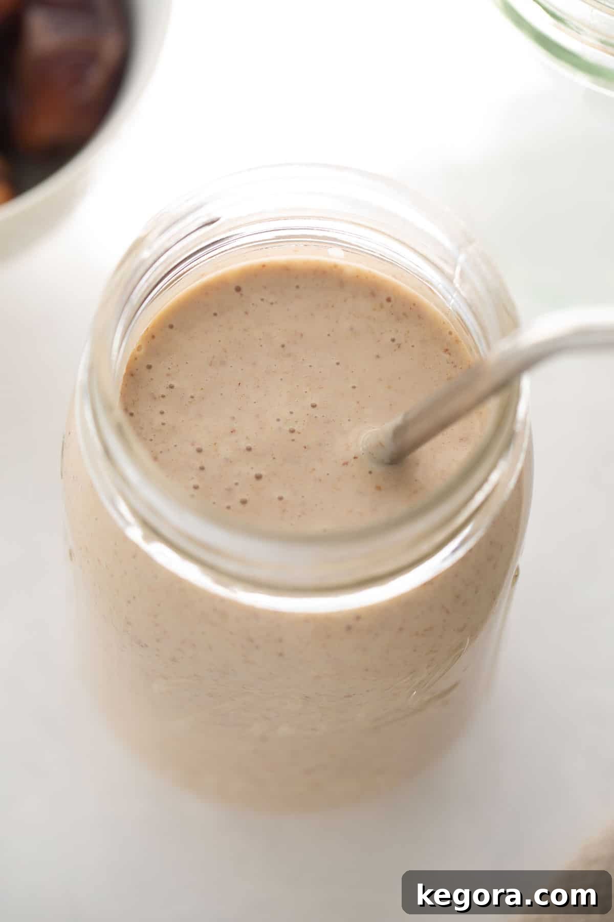 Healthy Banana Date Smoothie Refreshing and healthy banana date smoothie served in a clear glass with a straw, garnished for a perfect morning or afternoon treat.