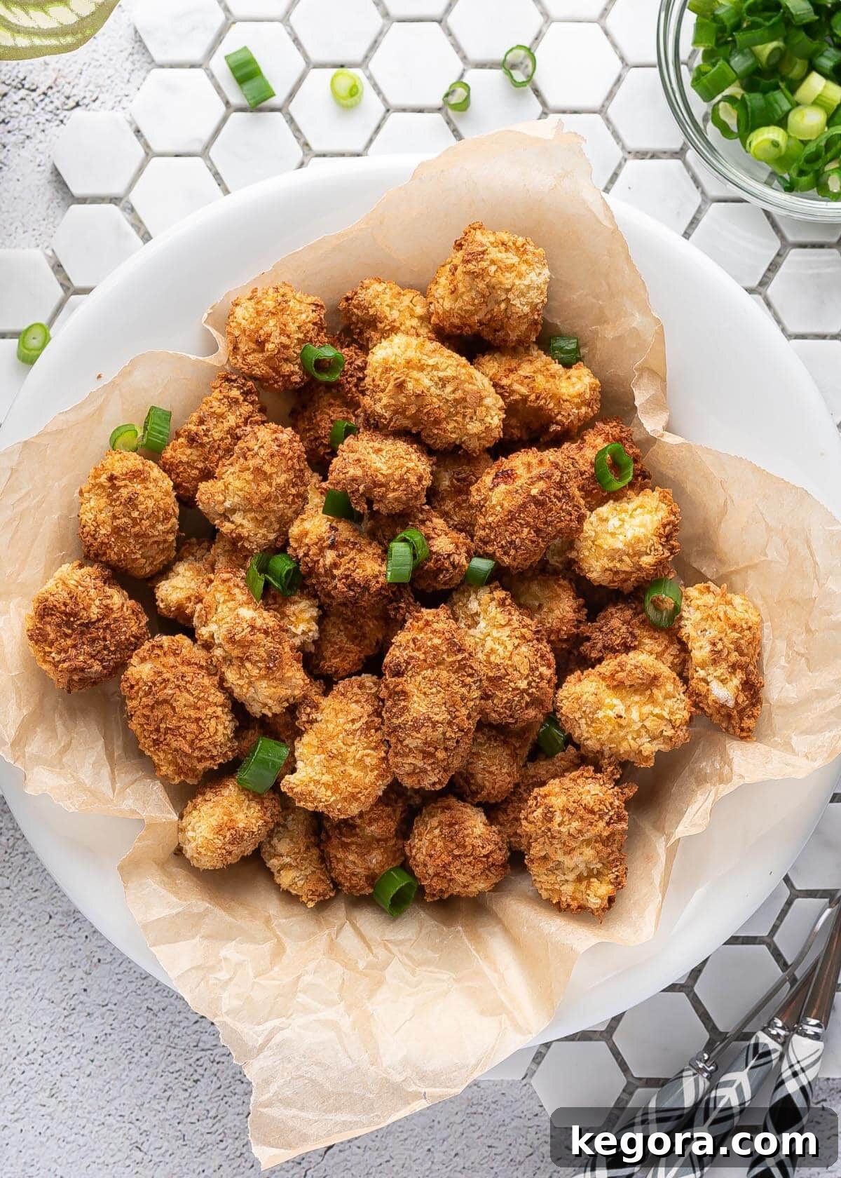 Air Fryer Popcorn Chicken in a white bowl, garnished with parsley