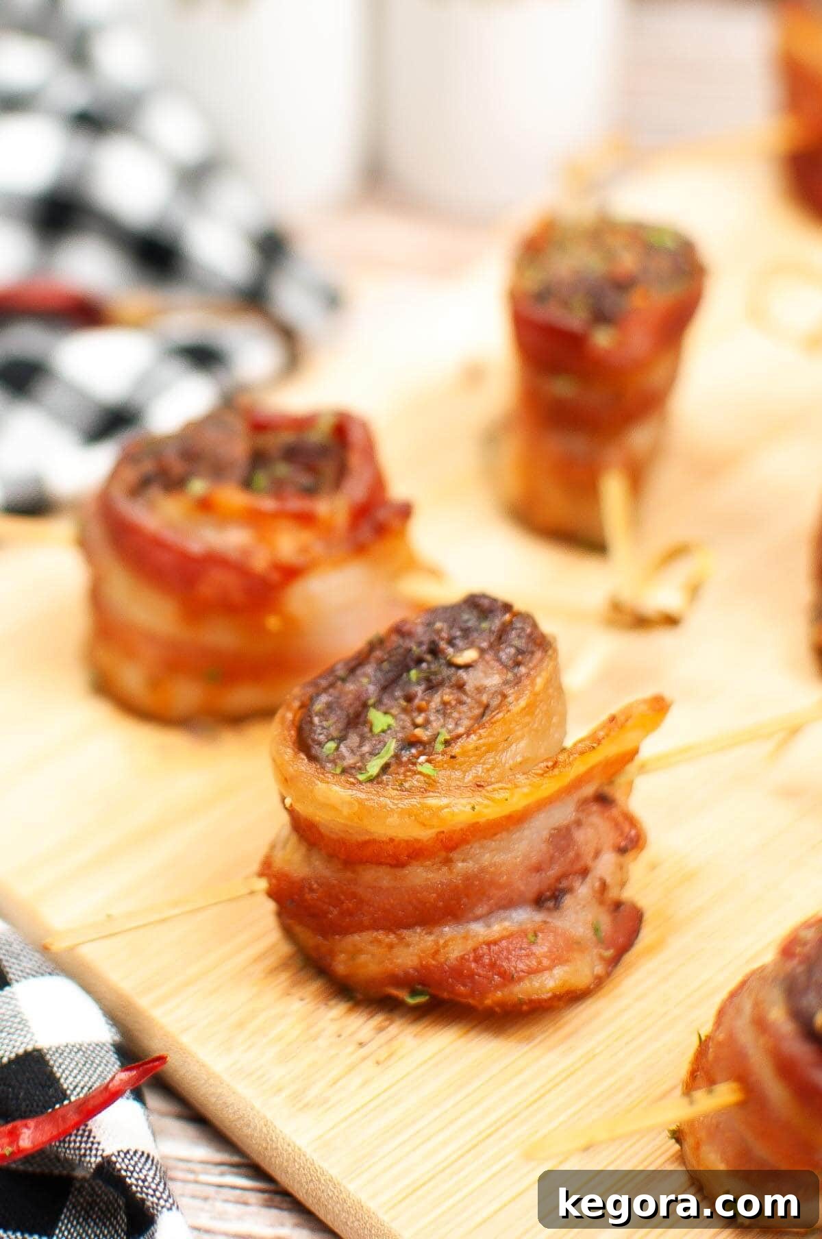 A serving of golden-brown Air Fryer Bacon Wrapped Steak Bites arranged beautifully on a rustic wooden board, ready to be enjoyed.