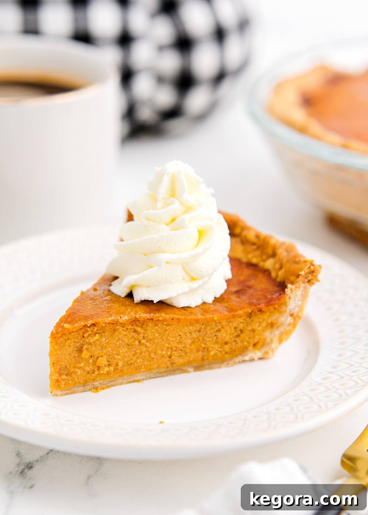 Golden Air Fryer Pumpkin Pie 2 Air Fryer Pumpkin Pie on a white plate, garnished with whipped cream and a sprinkle of cinnamon