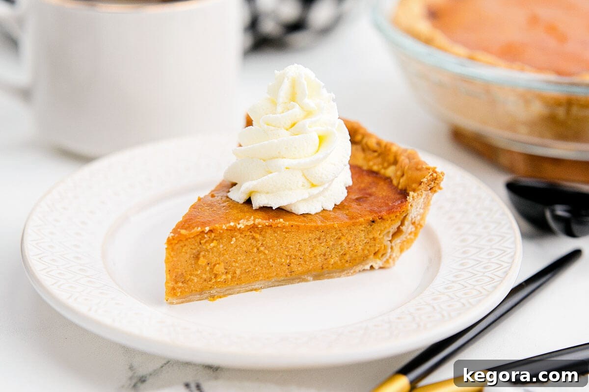 Golden Air Fryer Pumpkin Pie 5 A whole pumpkin pie on a white serving plate, beautifully baked and ready to be sliced.