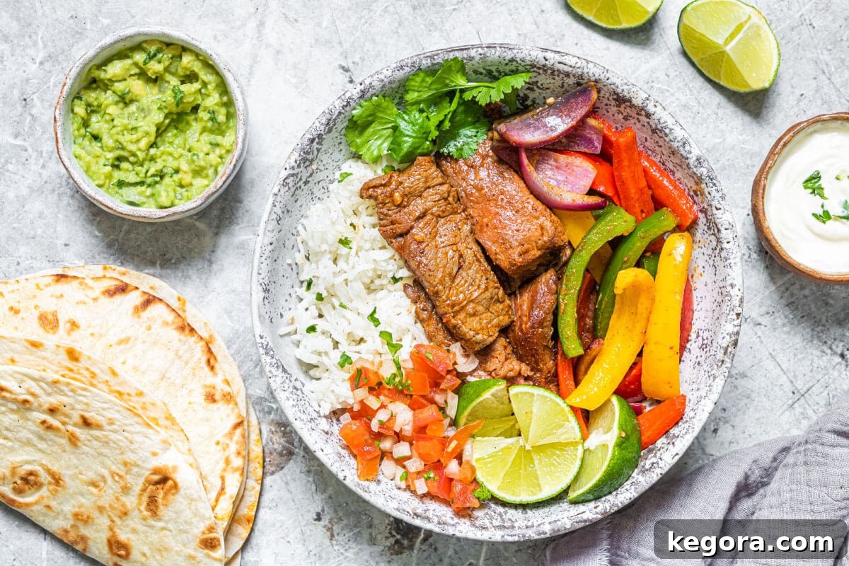 Air Fryer Fajitas with tortillas and garnishes on a grey plate