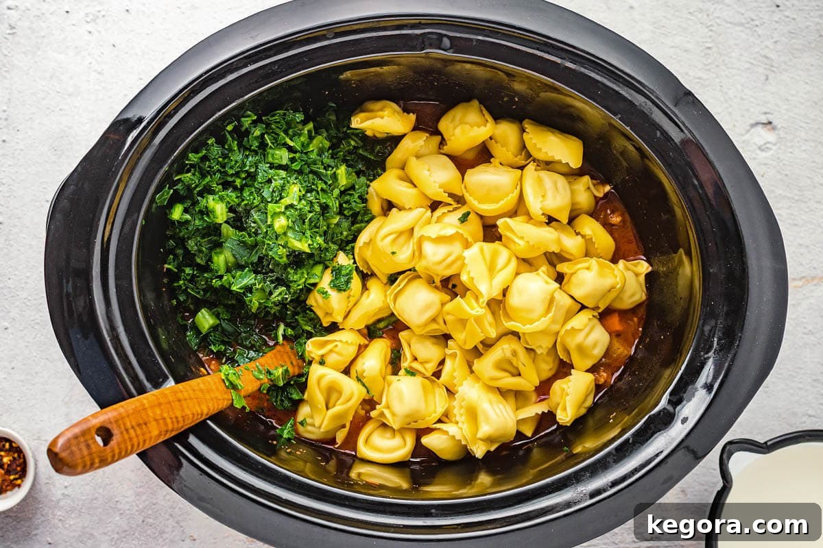 adding tortellini and kale to crock