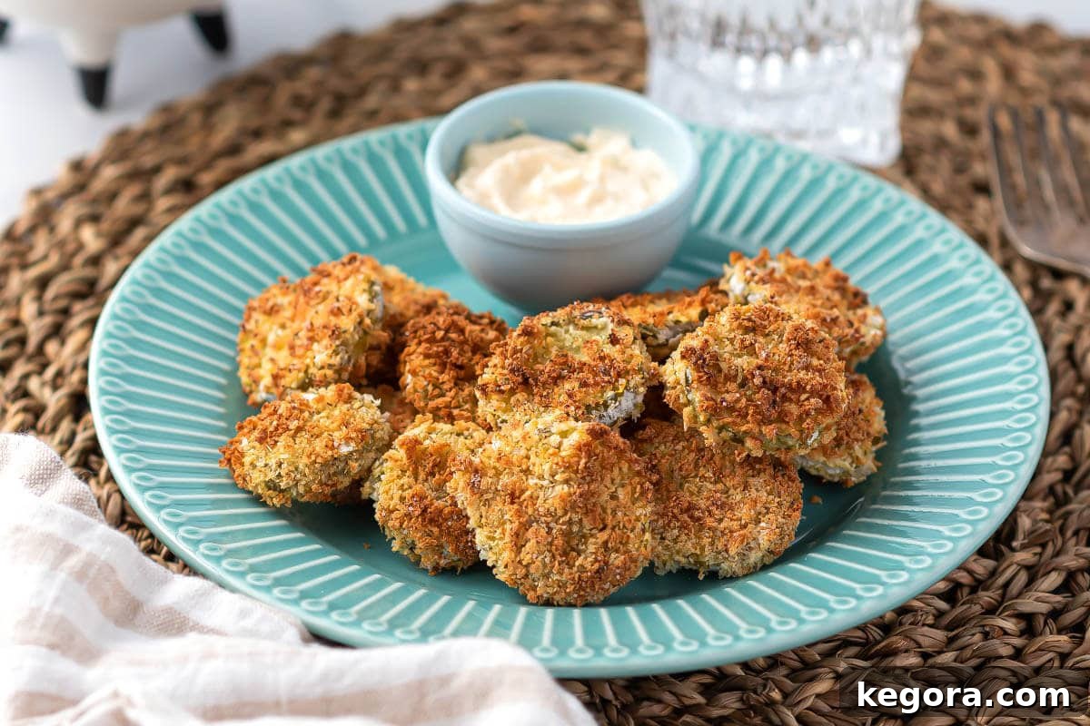 A blue ceramic plate holding several perfectly golden air fried pickles, ready to be served