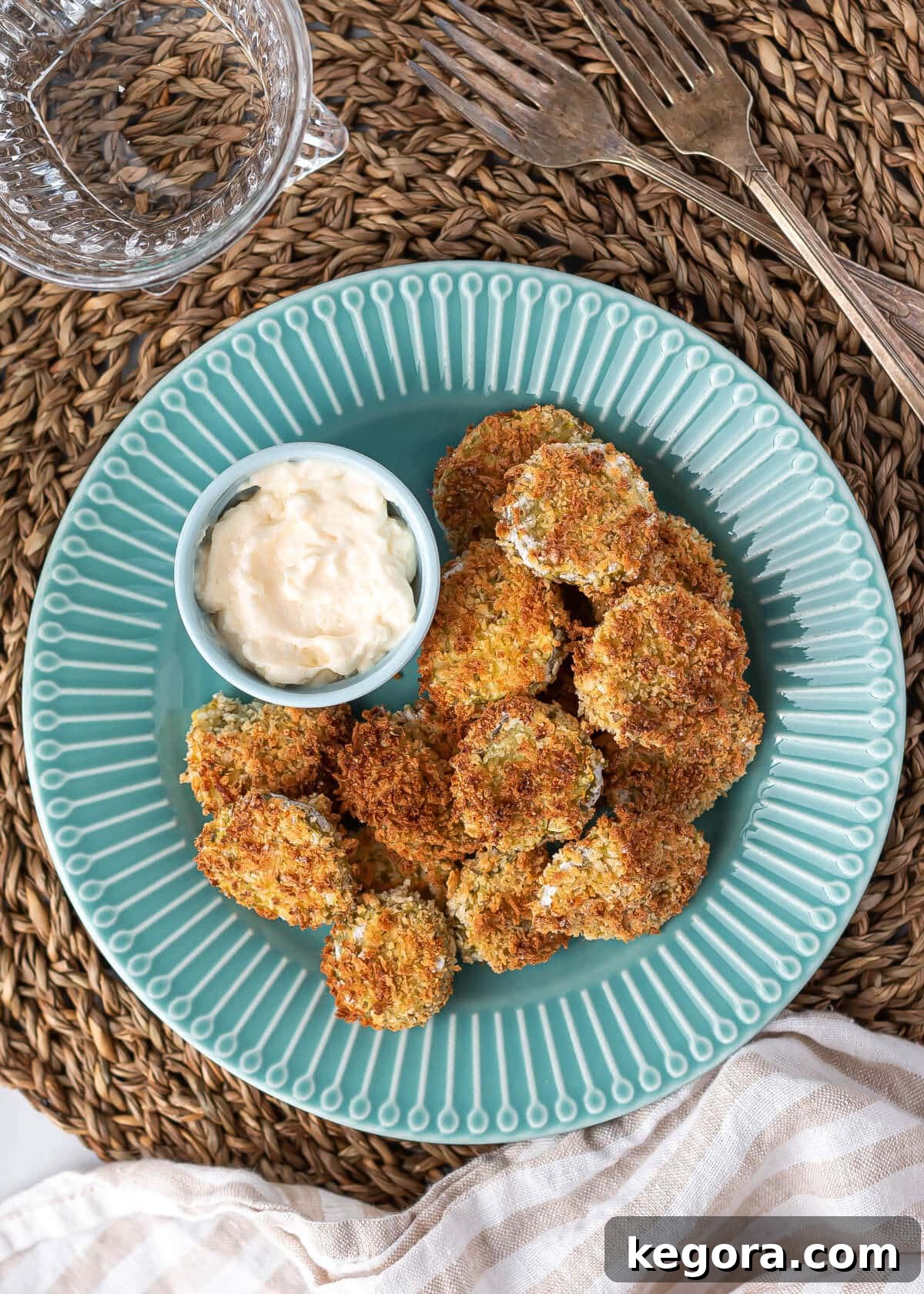 A vibrant blue plate showcasing a generous serving of crispy air fried pickles, beautifully presented and ready to be enjoyed