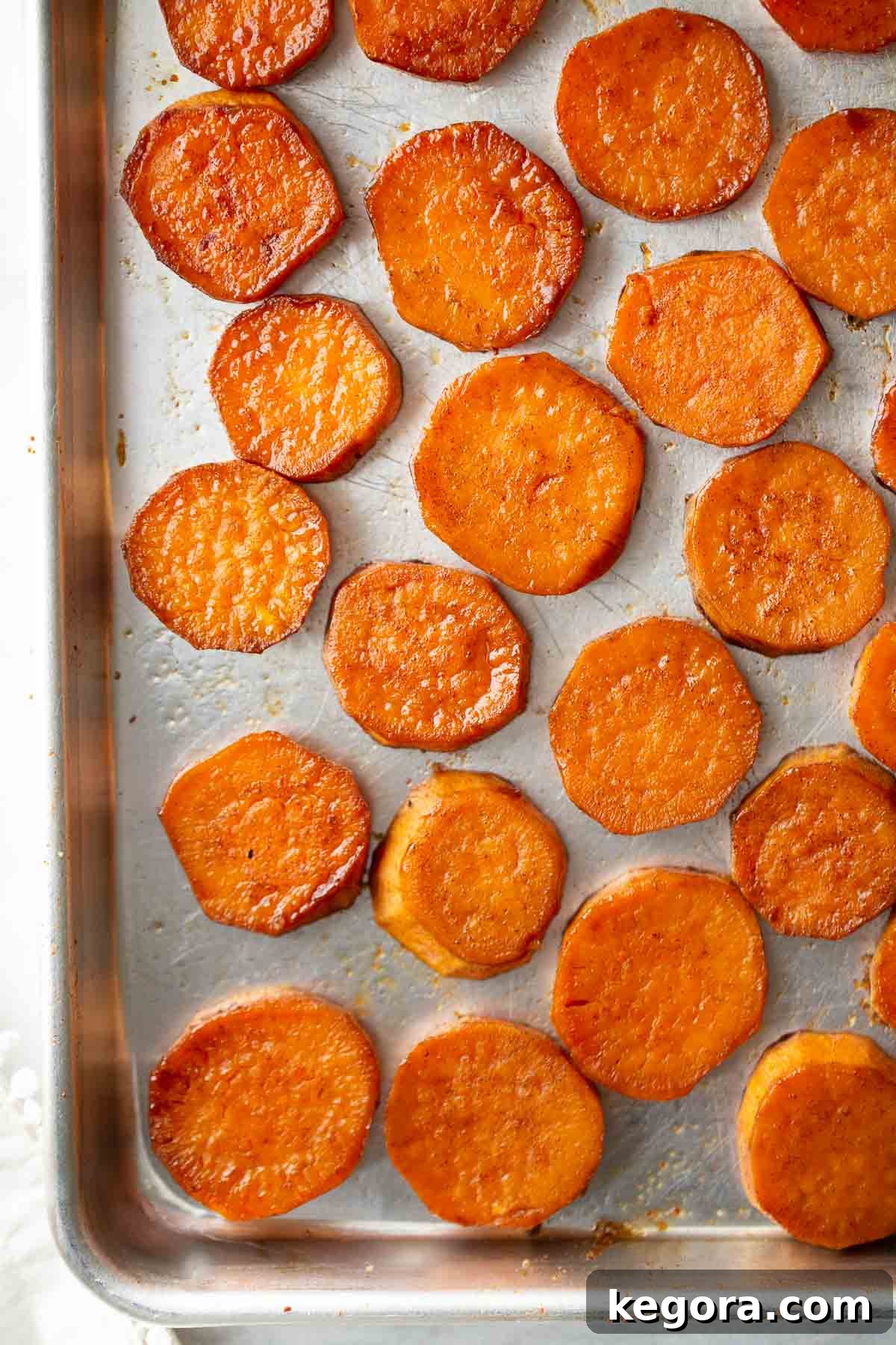 Perfectly roasted sweet potato medallions with caramelized edges on a baking pan, ready to serve. Ideal for a healthy side dish.