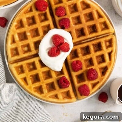 Gluten-free waffles on a plate with whipped cream and berries