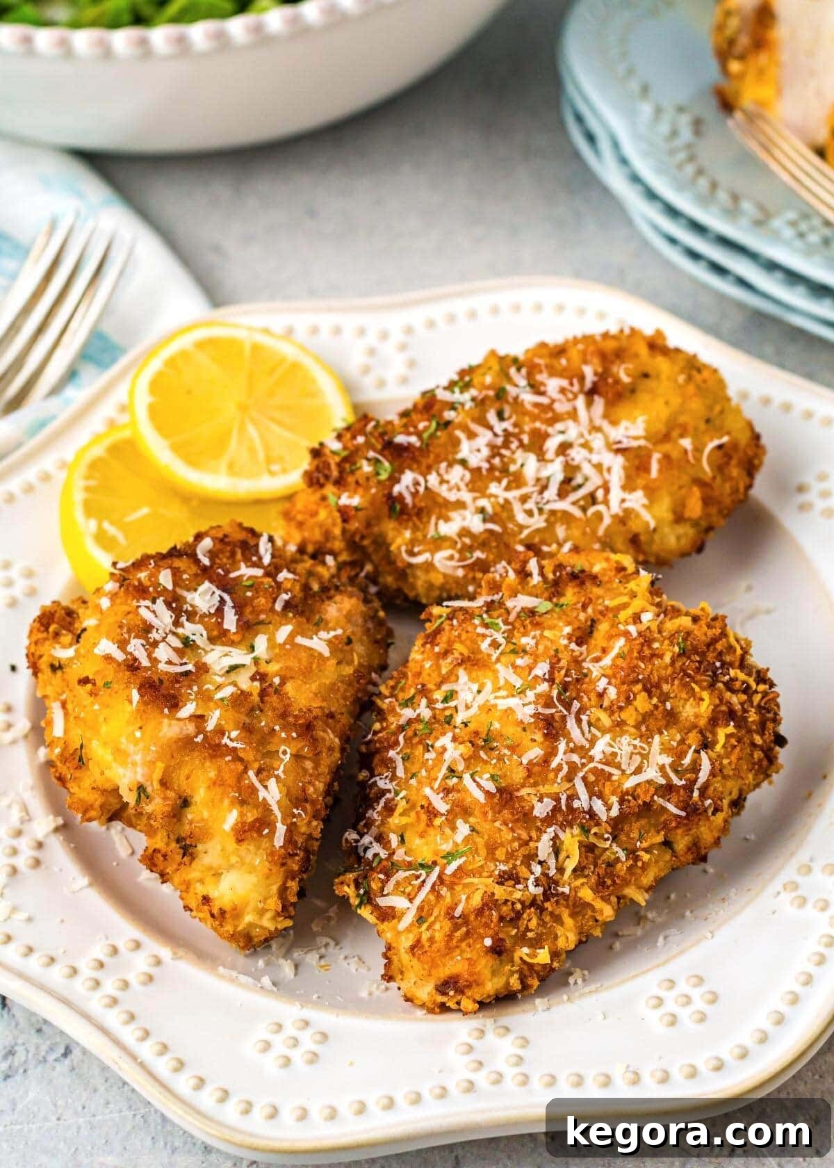 Air Fryer Parmesan Crusted Chicken on a white plate with lemon