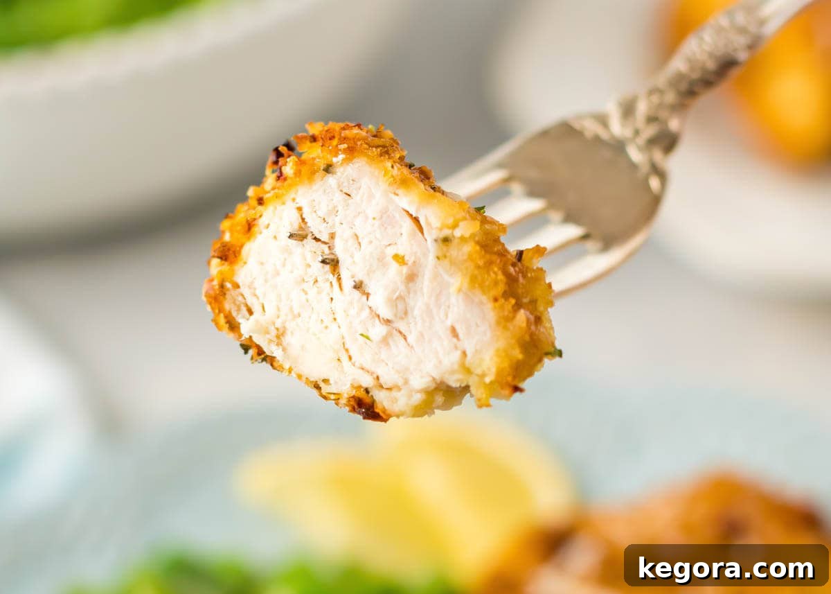 Air Fryer Parmesan Crusted Chicken on a fork, showing the crispy crust and juicy interior