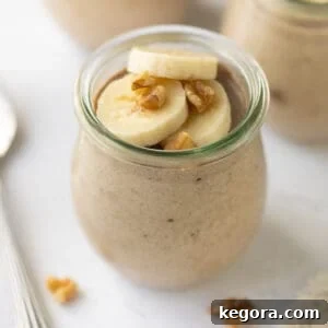 banana chia pudding in glass jar topped with banana slices and walnuts