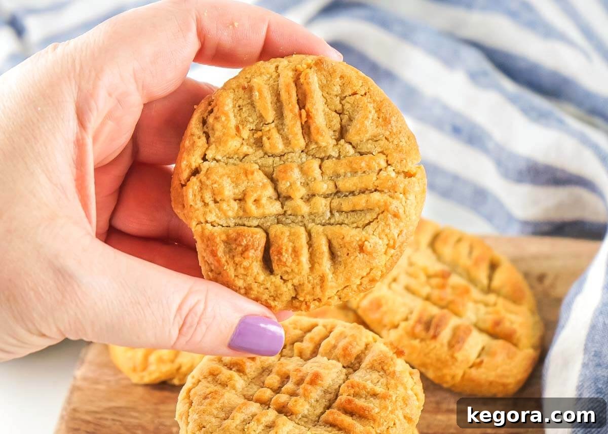 Air Fried Peanut Butter Cookie Delights 3 A hand reaching for a delicious Air Fryer Peanut Butter Cookie, showcasing its perfect texture