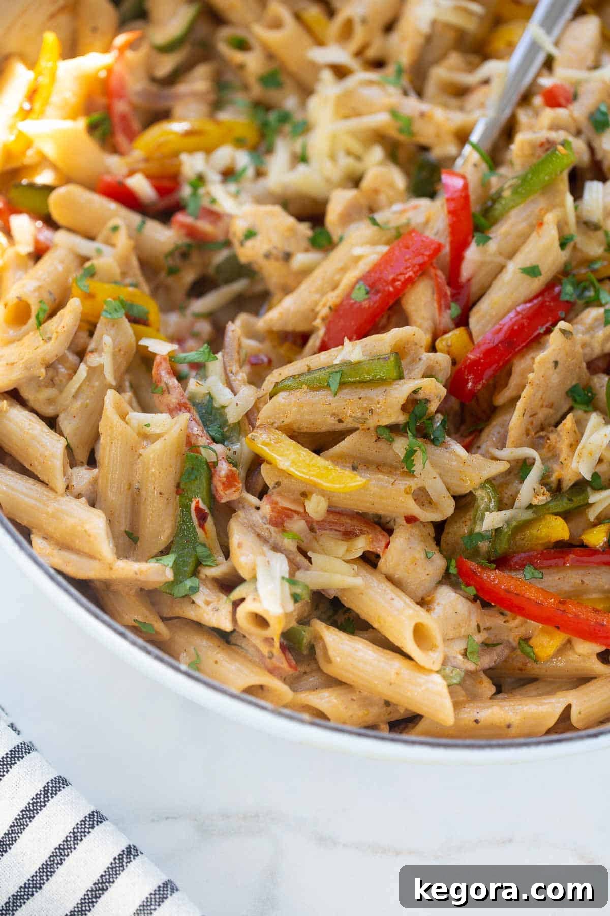 Fajita Pasta A close-up shot of the creamy gluten-free chicken fajita pasta in a skillet, showcasing its vibrant ingredients.