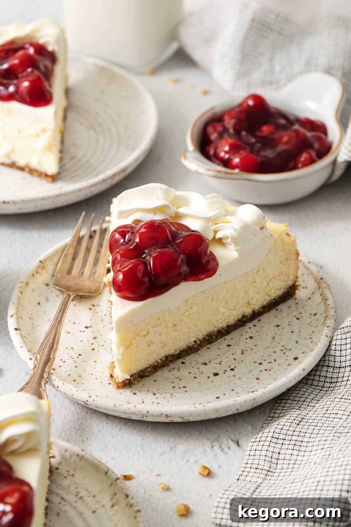 A beautifully sliced gluten-free cheesecake topped with vibrant cherry filling, ready to be served.