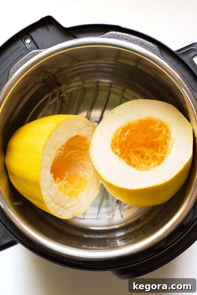 Squash Noodle Express 2 Instant Pot Spaghetti Squash halves resting on a metal trivet inside an electric pressure cooker, ready for the cooking process.